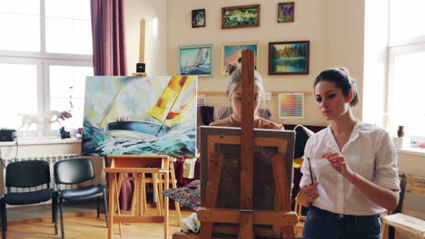 two women painting in an art studio
