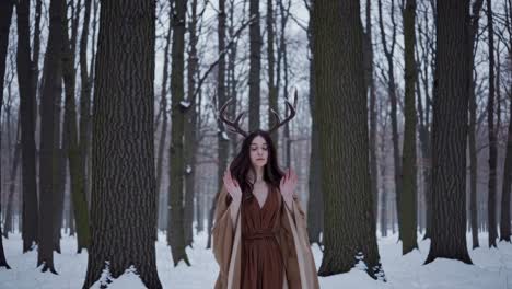 woman with deer antlers in a winter forest