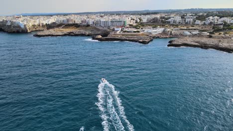 Luftdrohnenaufnahme-Eines-Motorboots-Auf-Dem-Weg-Nach-Polignano-A-Mare,-Italien