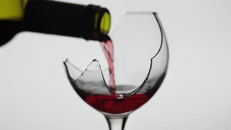 pouring red wine into a broken glass