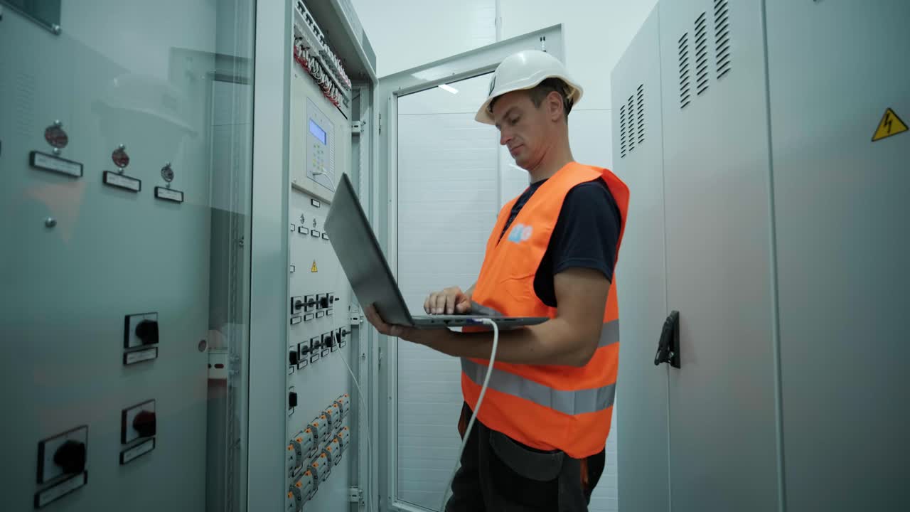 el ingeniero eléctrico que trabaja comprueba la tensión de corriente eléctrica y la sobrecarga en la parte delantera del gabinete del centro de carga o de la unidad de consumo para el mantenimiento en la sala principal del sistema de distribución de energía.