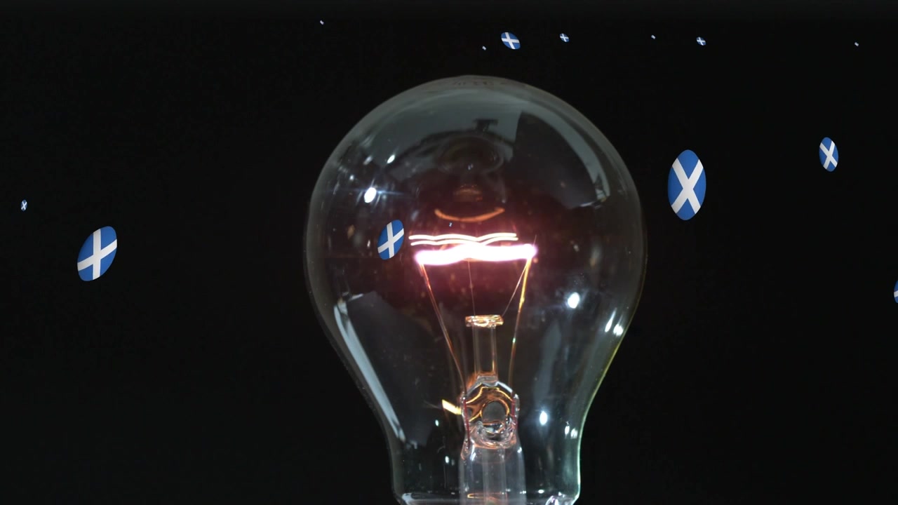 Animazione di palloni da rugby con bandiera della Scozia sopra una lampadina su sfondo nero