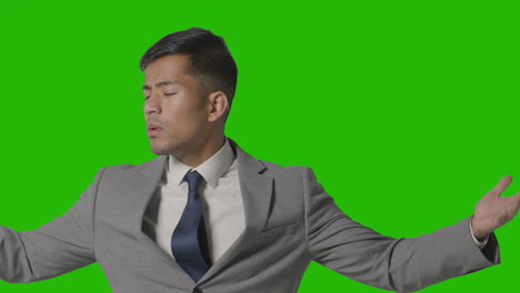 Portrait-Of-Frustrated-Businessman-In-Suit-Against-Green-Screen-Talking-To-Camera