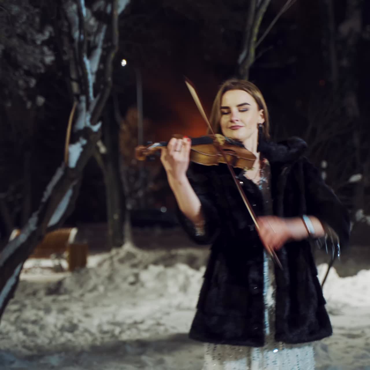Musician playing on violin at night