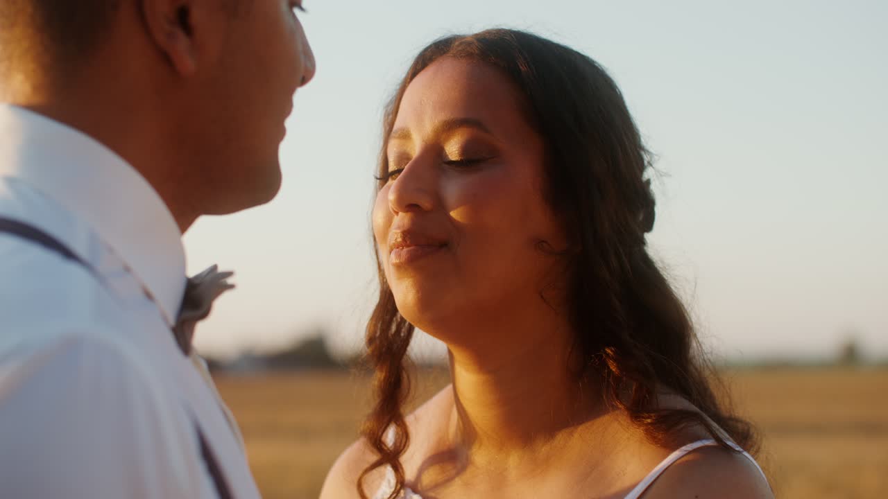 Una pareja besándose al atardecer.