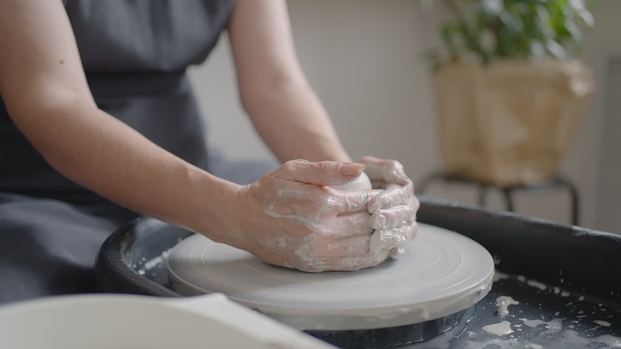Close-up of the hand of a grumpy woman master works on a potter's wheel in slow motion. Making utensils with your own hands