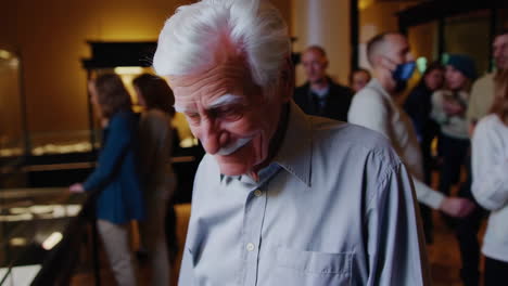 elderly man looking at artifacts in a museum