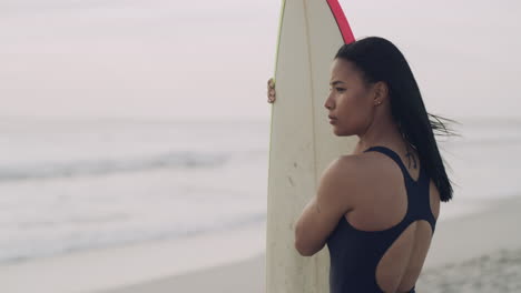 woman at the beach with a surfboard