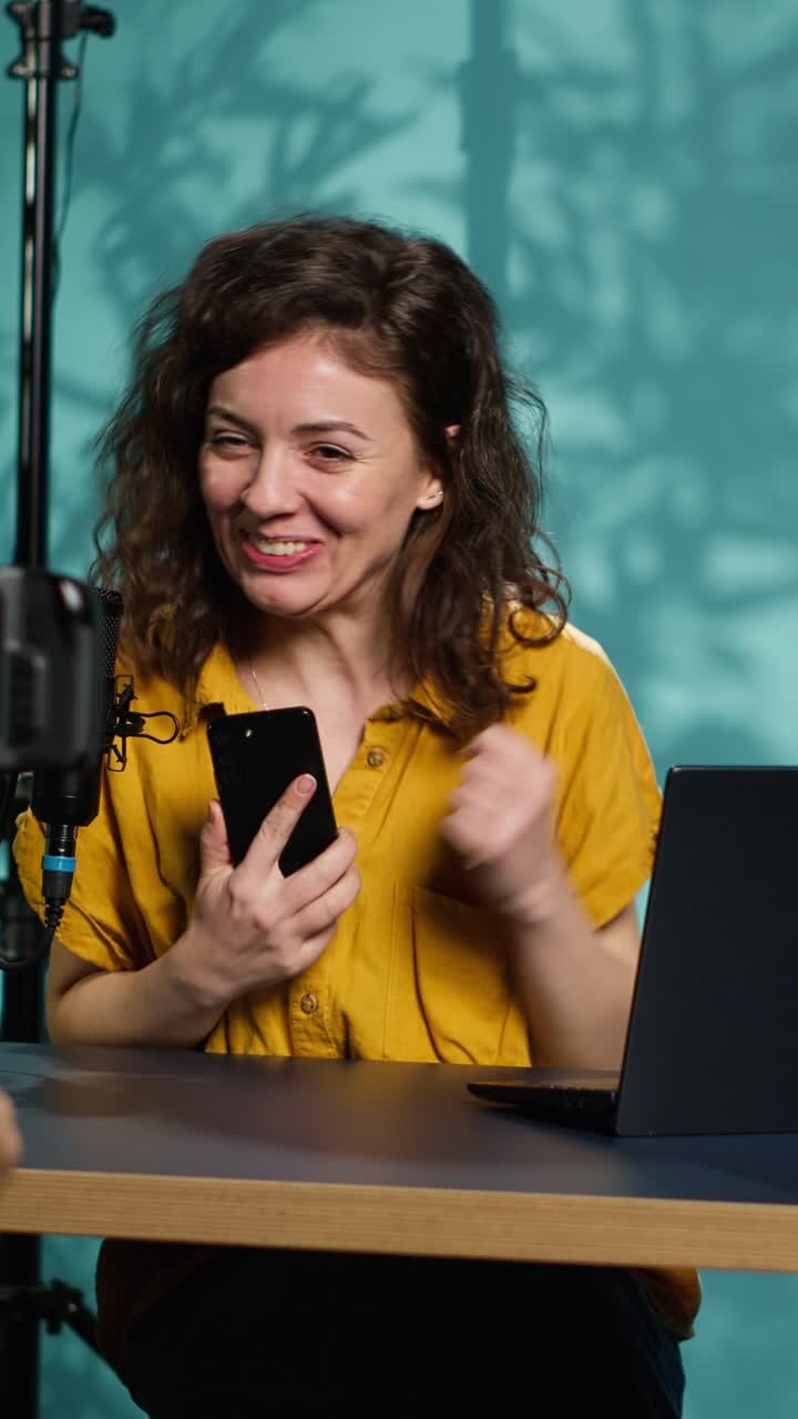 Donna entusiasta che reagisce a un contenuto su smartphone mentre filma un video