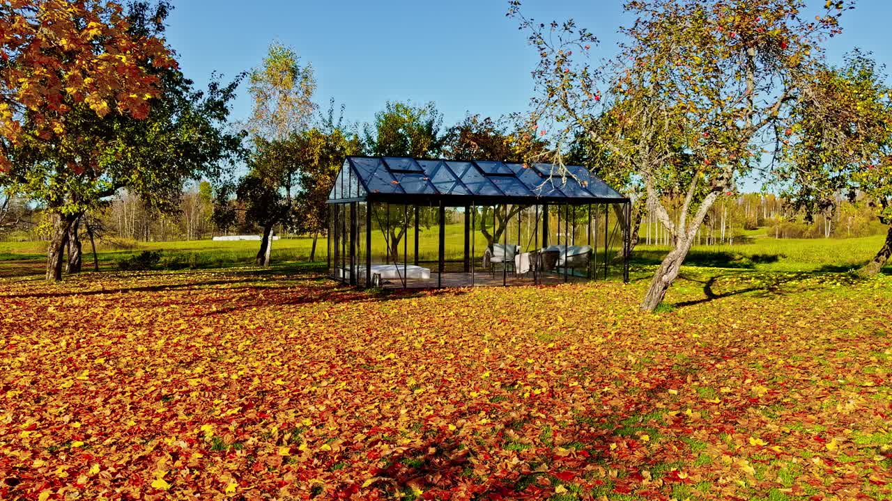 Greenhouse surrounded by autumn forest trees and colorful foliage, glowing in soft golden light
