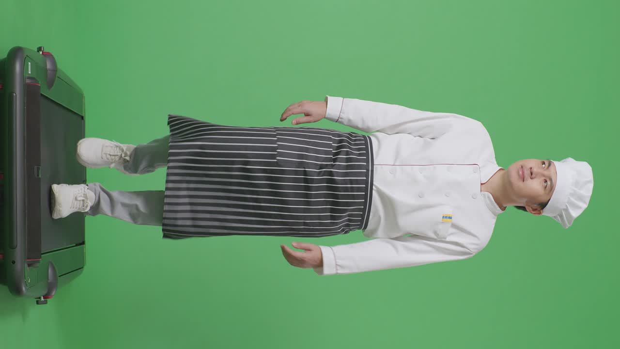 아시아 남자의 몸이 가득한 요리사는 트레드밀을 고 녹색 스크린 배경 스튜디오에서 주변을 둘러보고 있습니다.