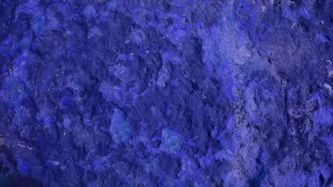 4k rain drop on heavy hard damage violet granite stone surface of cave for interior wallpaper