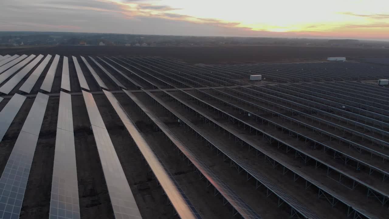 Luftfoto med drone af store solpaneler på en solcellepark ved lys solnedgang i det tidlige vinter. Solcellekraftværker.