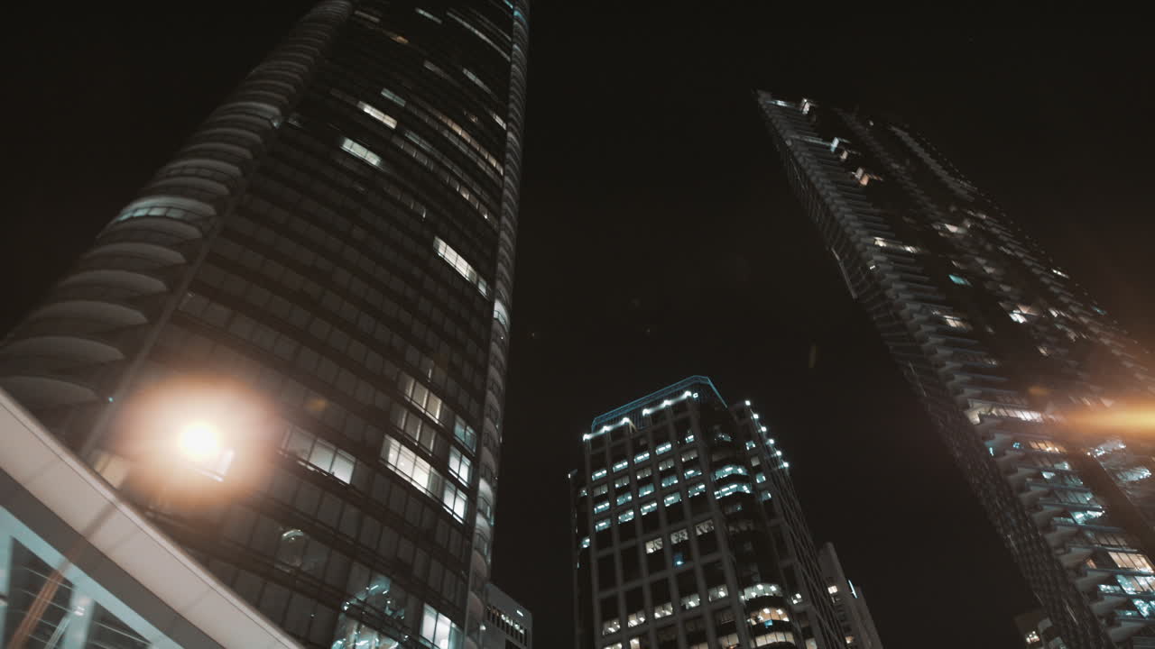 toma dinámica nocturna de rascacielos oscuros en el centro de vancouver, canadá.