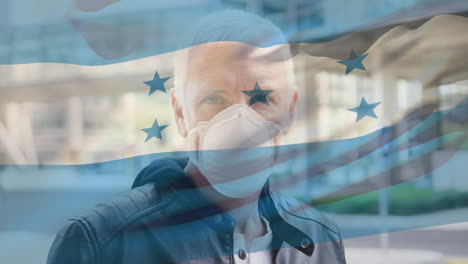 animation of flag of honduras waving over man wearing face mask during covid 19 pandemic