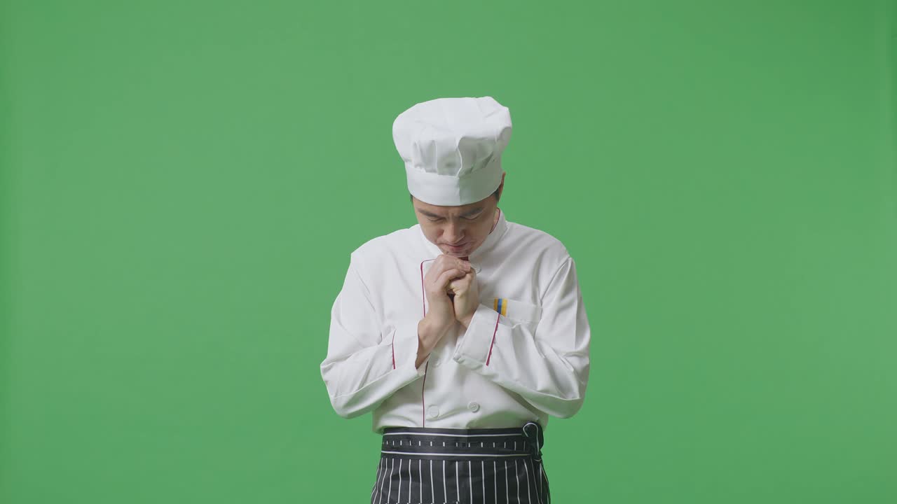 Asian Man Chef Praying For Something While Standing In The Green Screen Background Studio