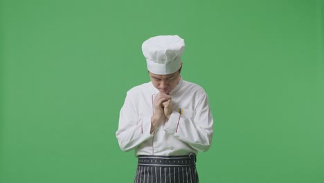 Asian Man Chef Praying For Something While Standing In The Green Screen Background Studio