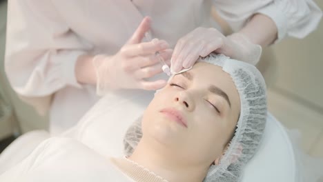 cosmetologist performing facial injection procedure