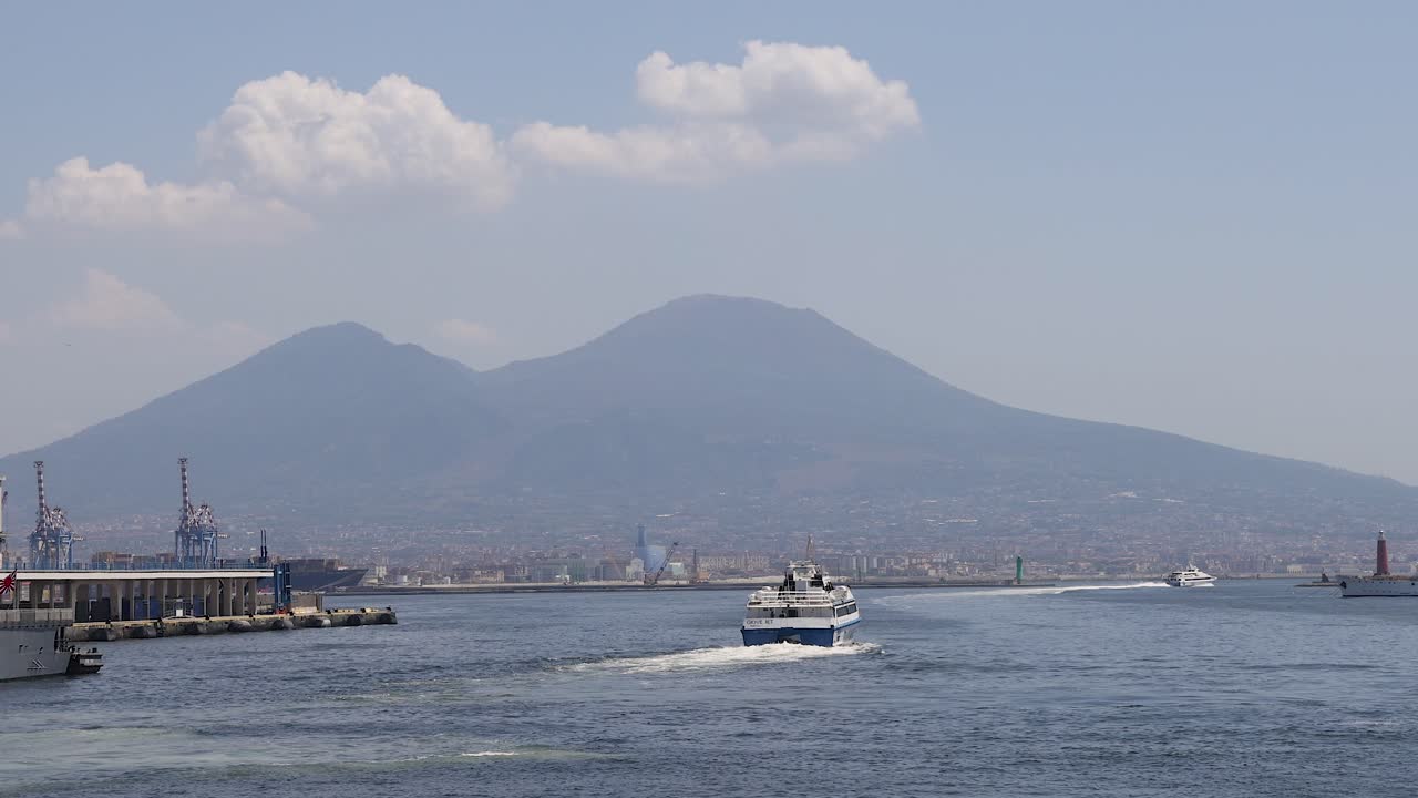산의 배경으로 물을 가로질러 움직이는 보트
