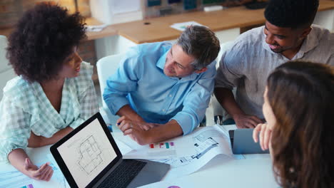 Elevated-View-Of-Male-And-Female-Business-Team-With-Laptop-Meeting-In-Modern-Office