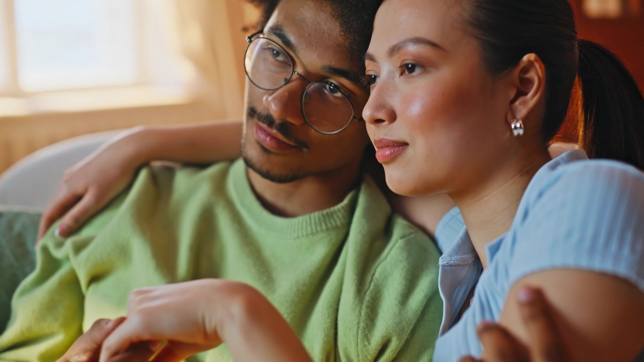 Closeup hands touching sofa. Camera pan multiracial couple cuddling home love.