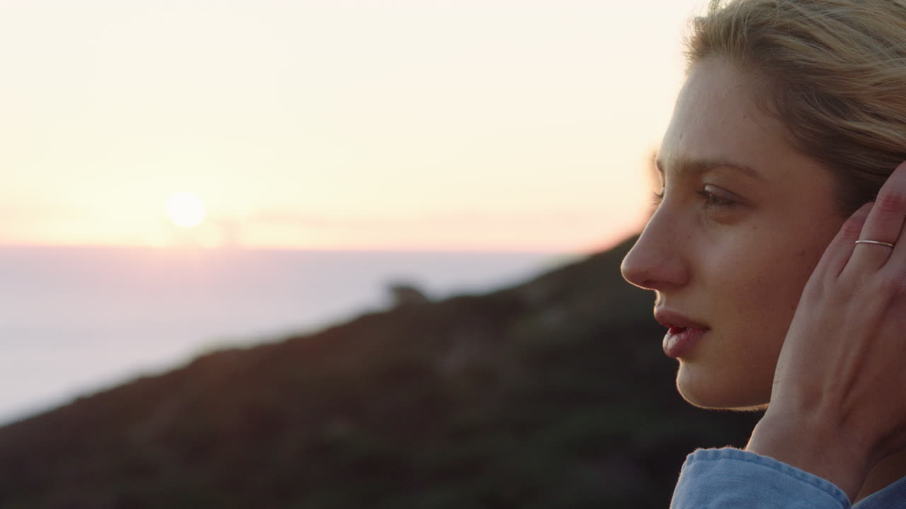 retrato de mujer feliz contemplando el futuro disfrutando de un estilo de vida despreocupado sintiéndose positiva relajándose mirando la puesta de sol junto al mar