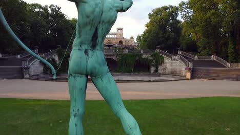 Perfect-aerial-drone-flight-of-a-Men-statue-with-bow-and-arrow-in-front-of-a-royal-palace