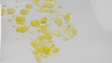 aceite vegetal de color amarillo que se vierte en el agua formando burbujas
