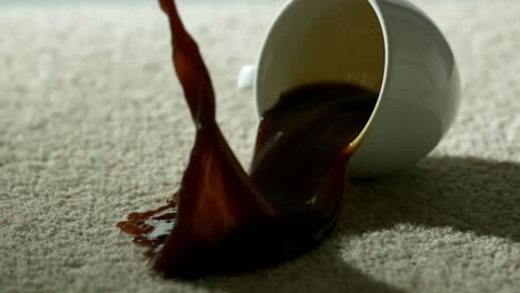 una taza de café cayendo y derramándose sobre la alfombra