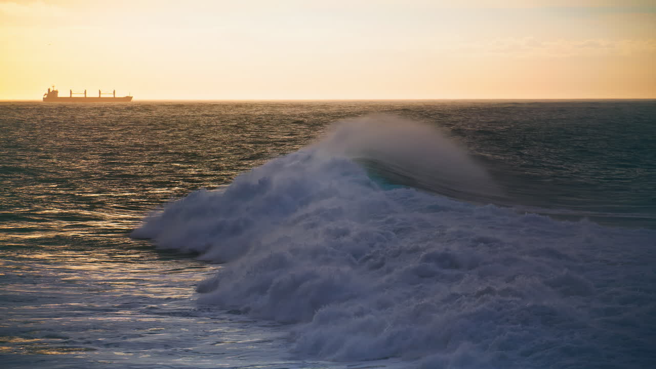 olas de invierno rodando la orilla en cámara lenta silueta de barco de viaje en el horizonte