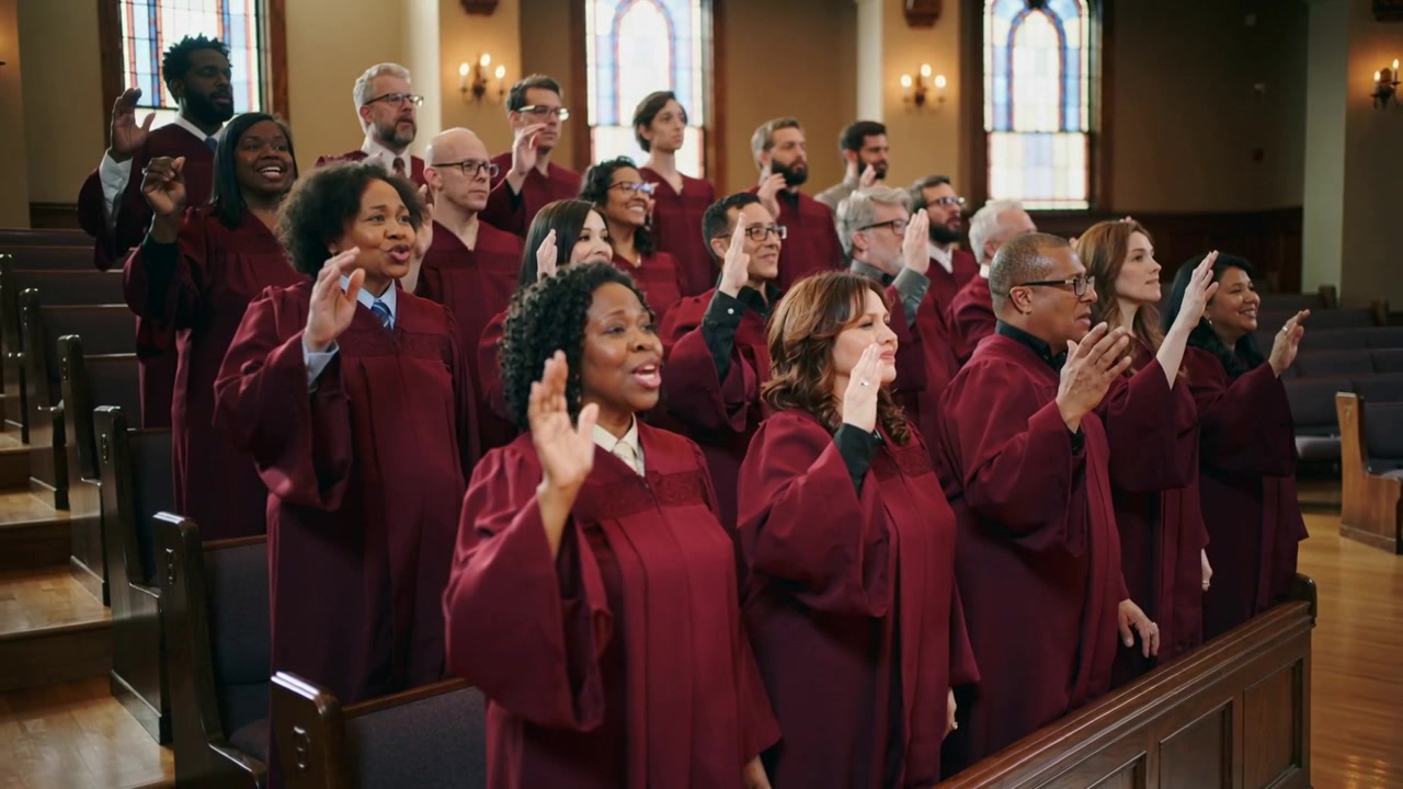 Coro cantando levantando las manos, proyectando después de la señal del director en el santuario, con túnicas granates para el culto.