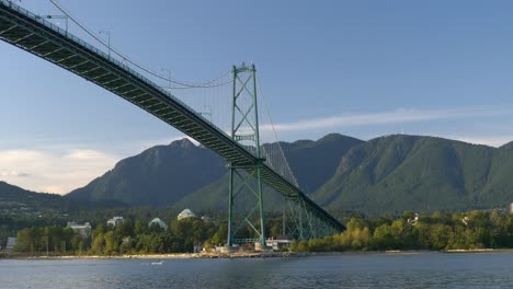 lions gate bridge over burrard inlet with mountain range in the background in vancouver, british columbia, canada