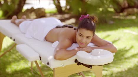 happy young woman having a hot stone massage
