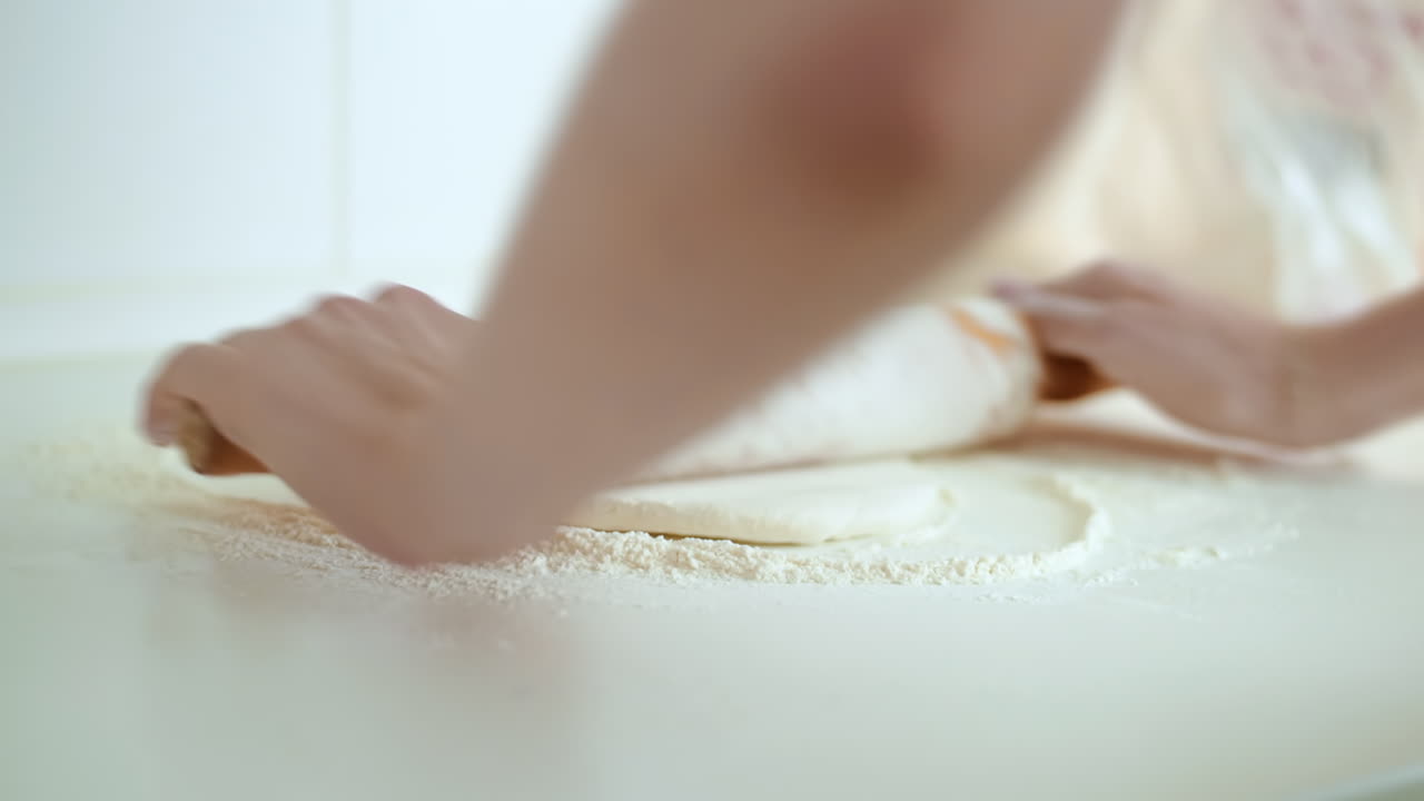 Woman rolling out dough for pizza. Slow motion