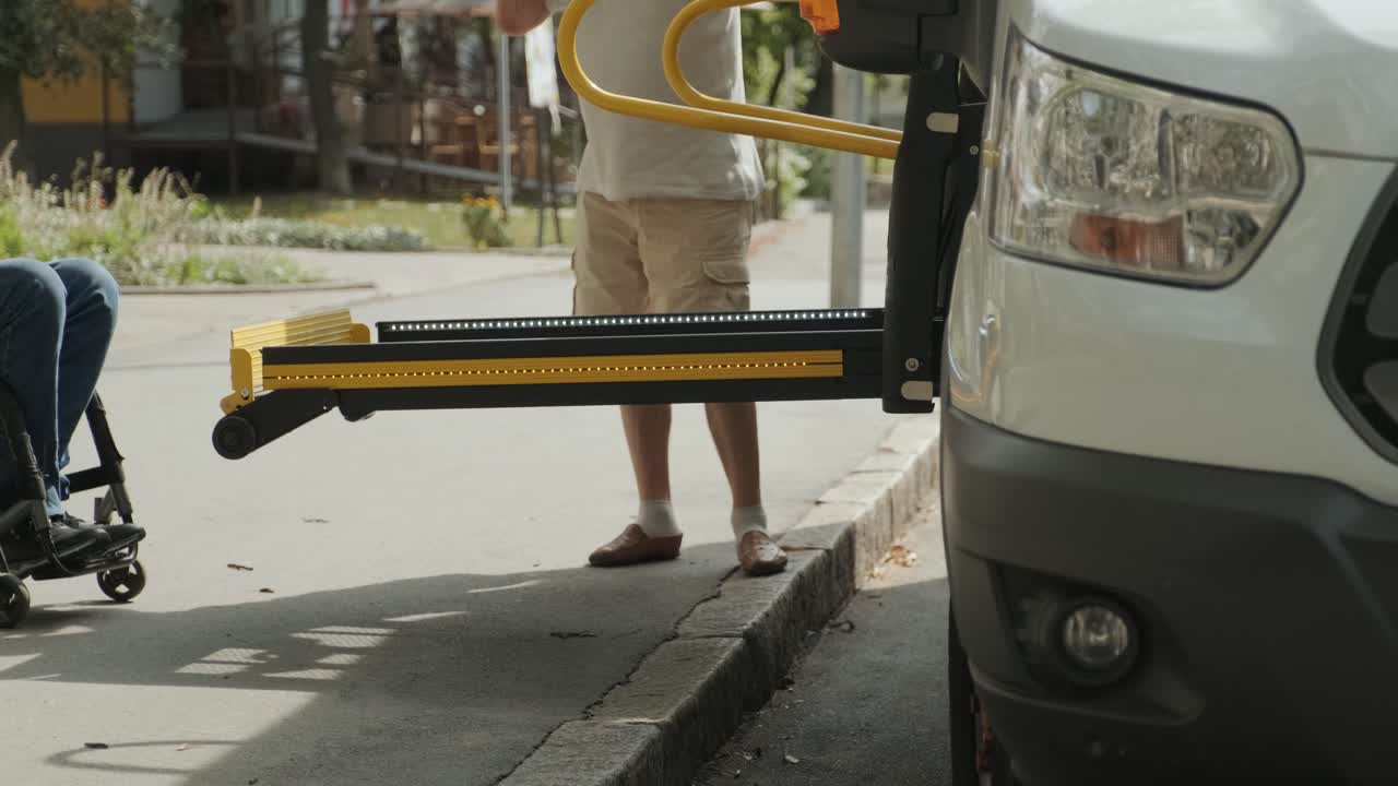 A man in a wheelchair on a lift of a vehicle for people with disabilities. Lifting equipment for people with disabilities - man in wheelchair near the vehicle