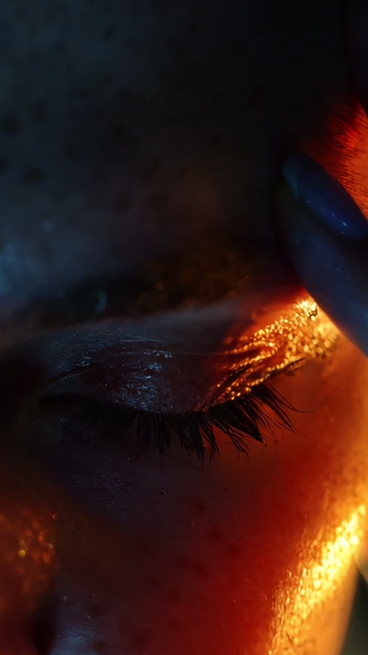 A woman with her hands on her head in a dark room. Concept of stress and exhaustion