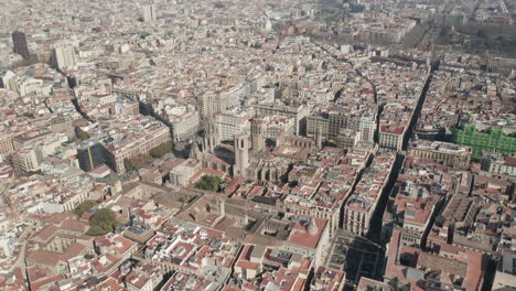 Aerial-view-of-cityscape.-Tilt-down-on-Cathedral-of-Barcelona,-historic-religious-landmark.-Barcelona,-Spain