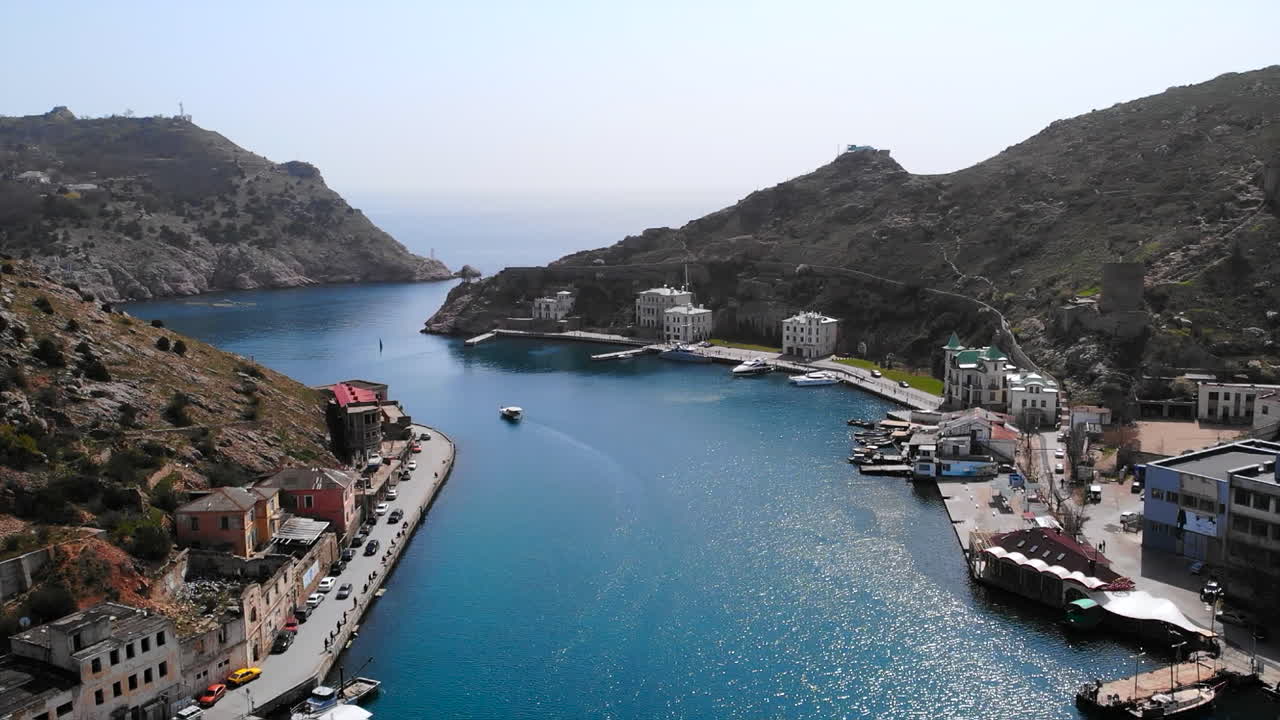 Aerial view of a coastal town in a bay surrounded by mountains