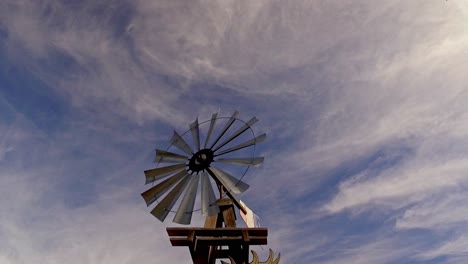 Alte-Windpumpe-Im-Cowboy-,-Farm--Und-Präriestil,-Die-Sich-Gegen-Einen-Blauen-Himmel-Dreht