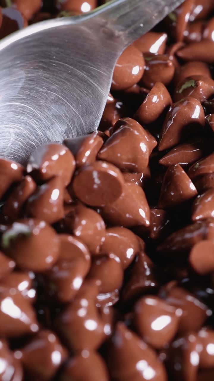 Spoon scooping chocolate chips from a pile