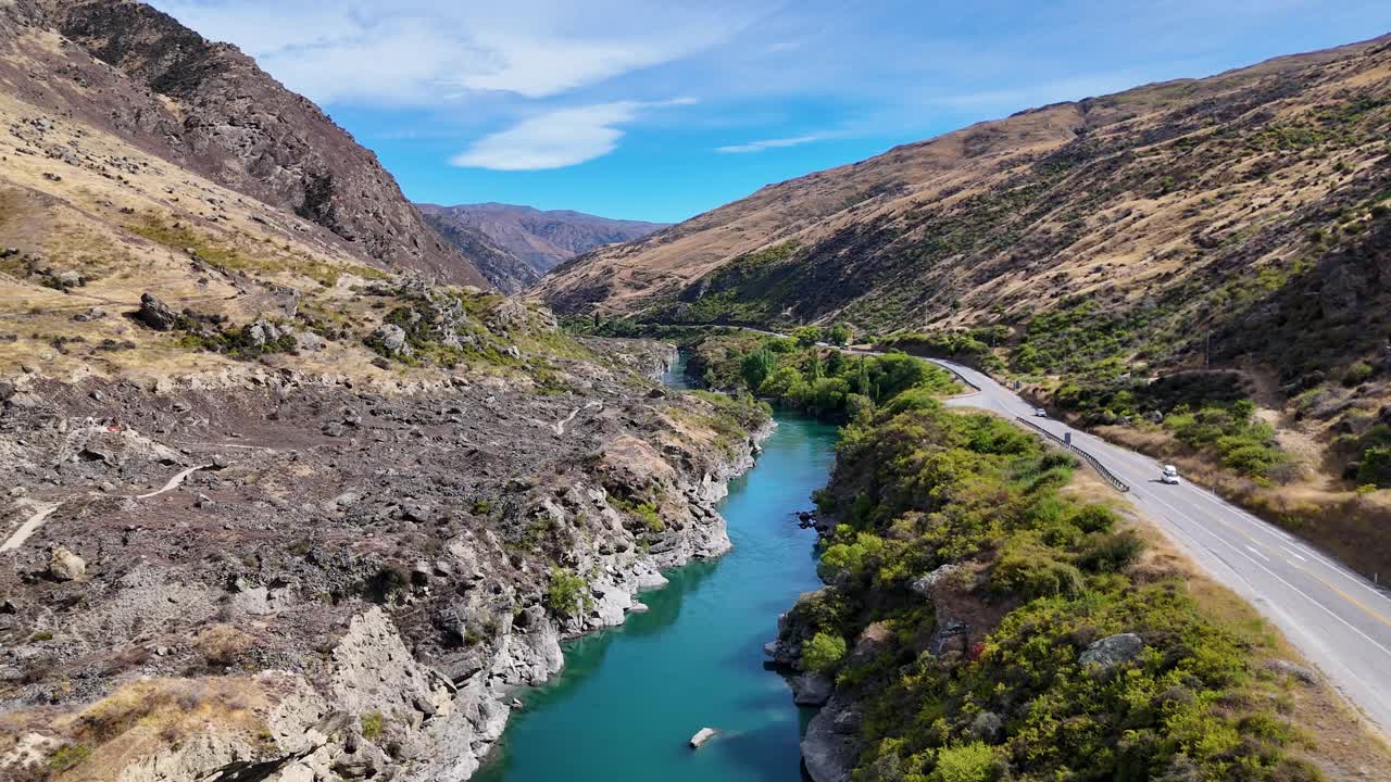 4K drone video flying along the Kawarau River near Queenstown, New Zealand. Clear waters wind through mountains and valleys, showcasing the stunning South Island landscape