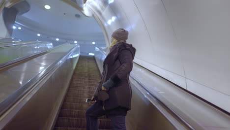 woman on escalator in modern metro station