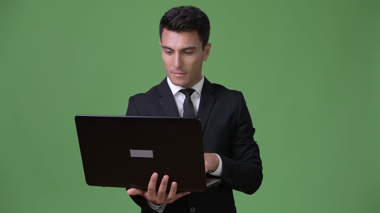 joven y guapo hombre de negocios hispano contra un fondo verde