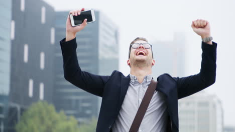 a-young-businessman-cheering-while-using