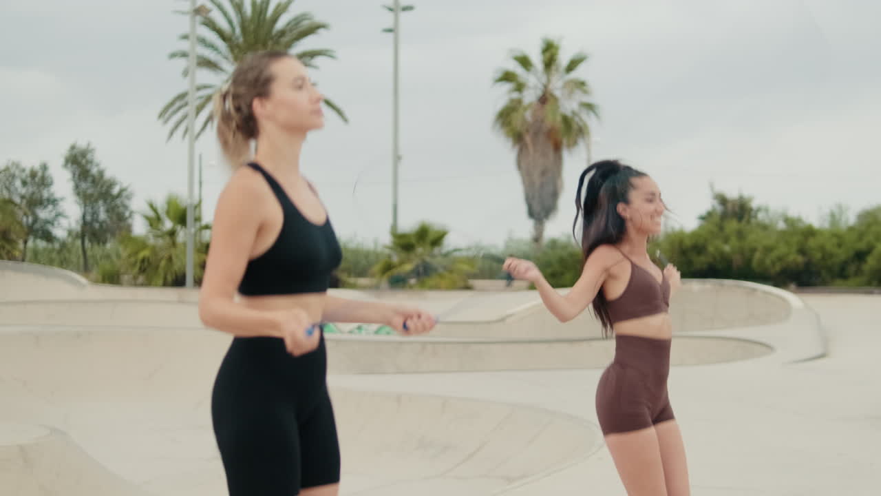 Two Fit Women Skipping Rope in the Park