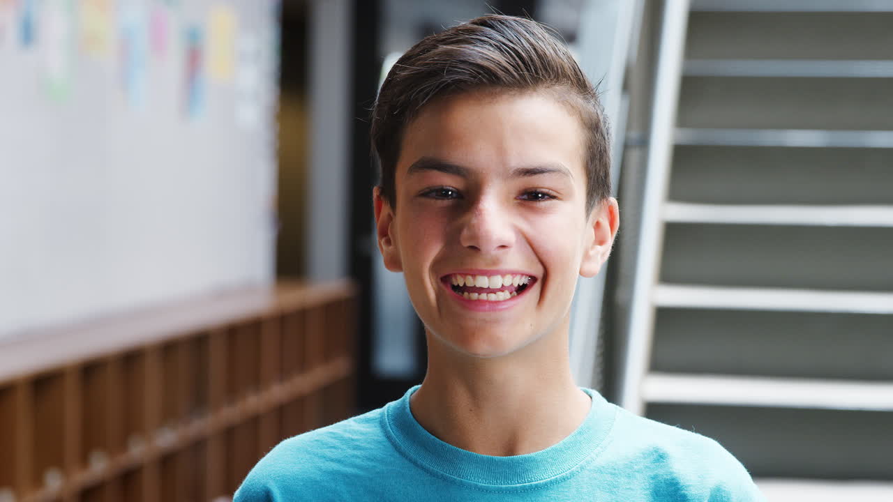 Portrait Of Male High School Student Standing By Stairs In College Building