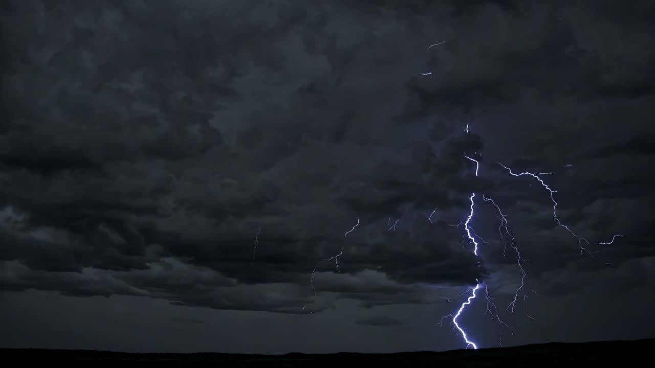 Dramatic wide-angle video shot of a stormy sky with lightning illuminating dark clouds