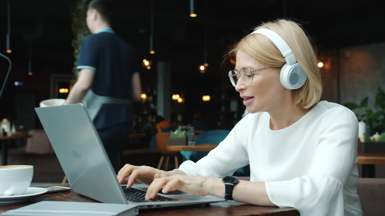 Kvinde arbejder på bærbar computer på en café