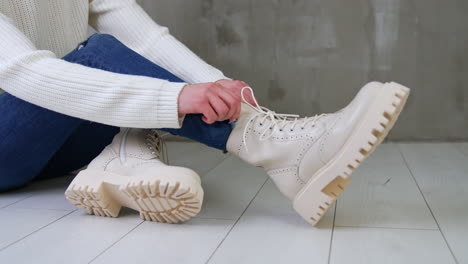 woman tying lace-up beige platform boots
