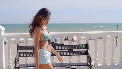 sexy young woman strolling along a promenade